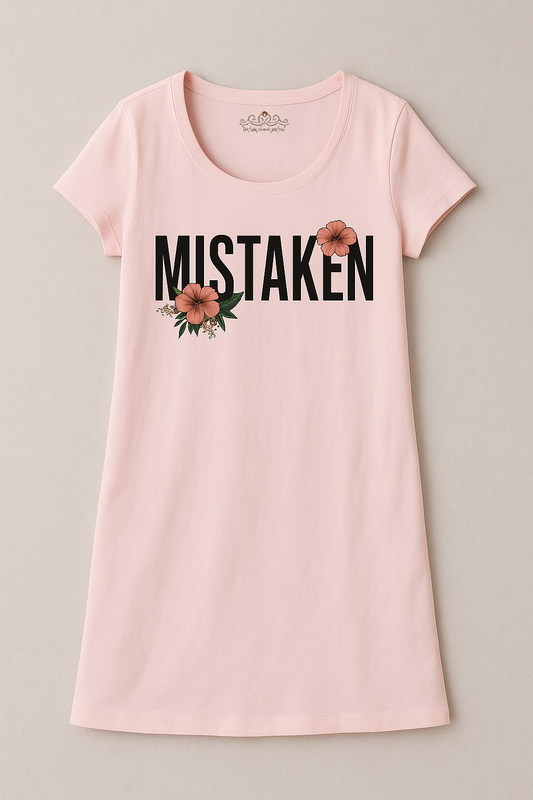 A pink long shirt with the word 'MISTAKEN' printed in black letters on the front, accompanied by a floral design